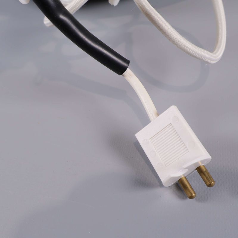 Närbild på vit europastickpropp och sladd till lampa