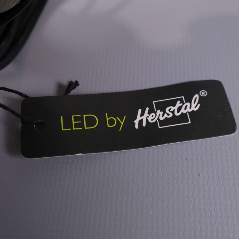 Etikett med text LED by Herstal vid lampans kabel