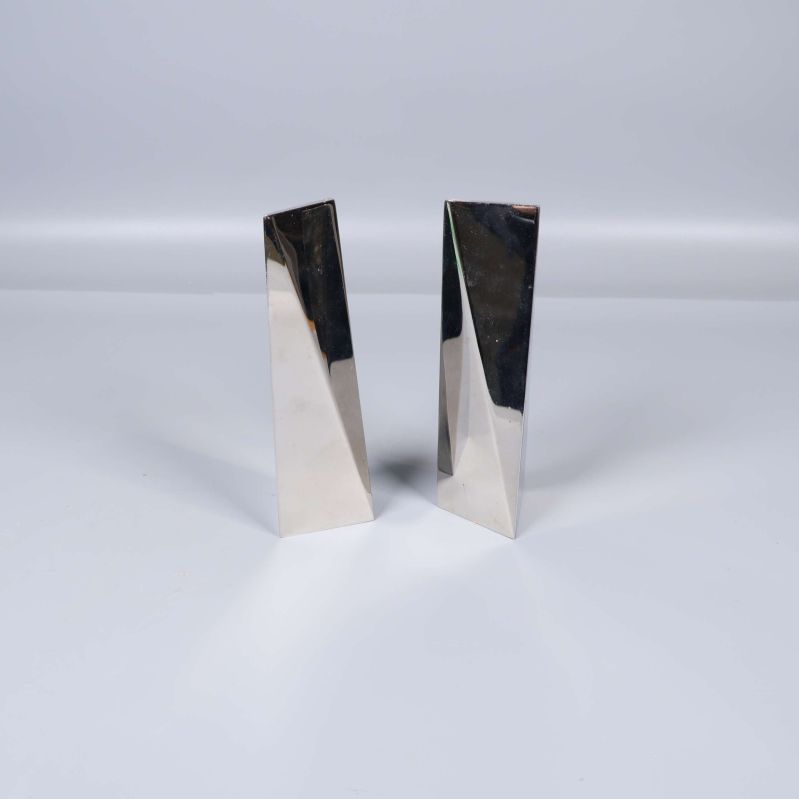 Två triangulära metalliska salt- och pepparkar stående tillsammans