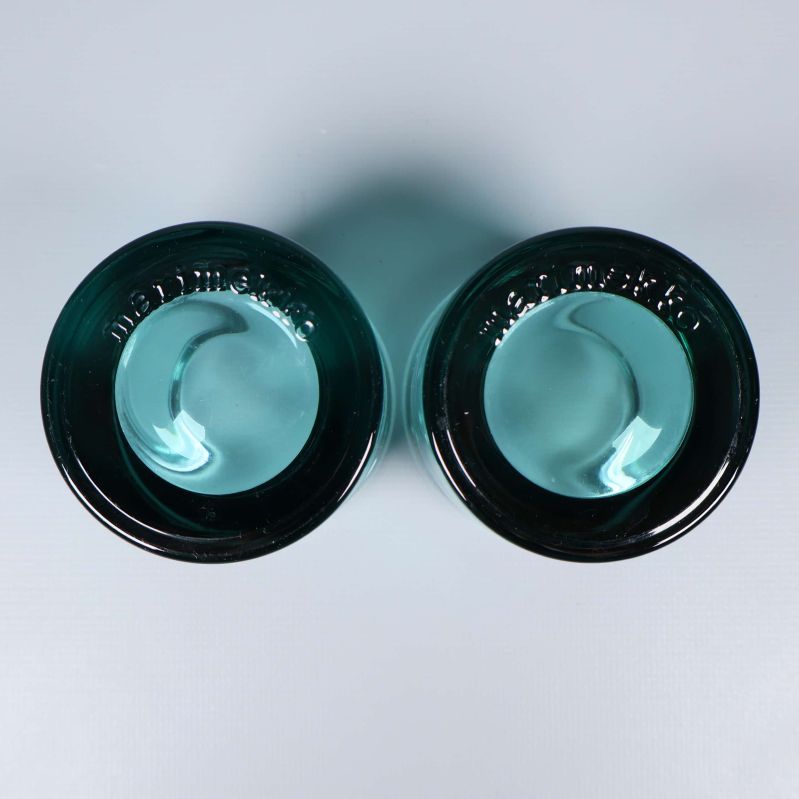 Två turkosa glaslyktor fotograferade ovanifrån