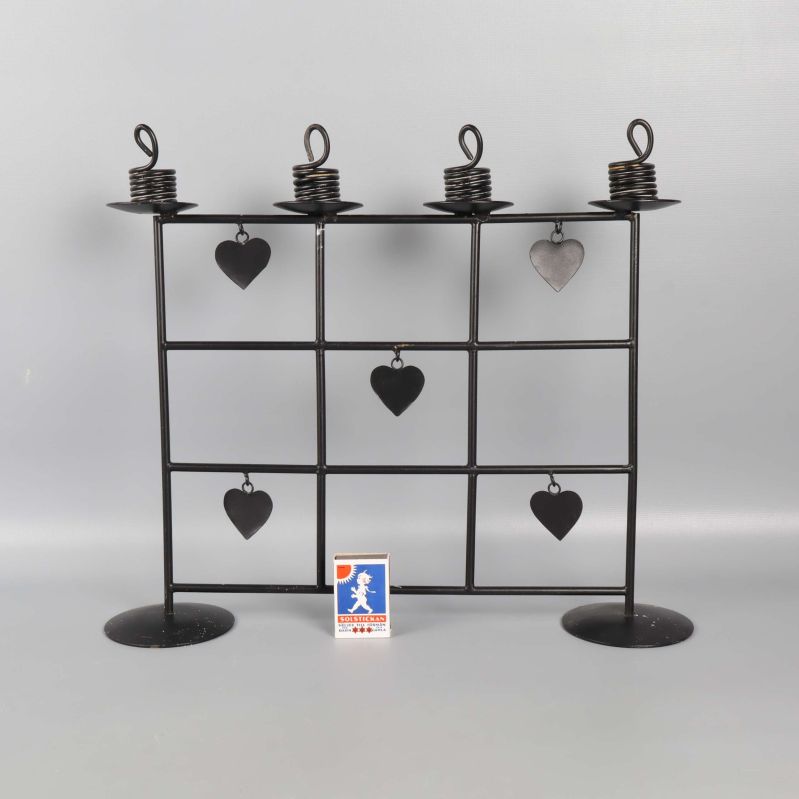 Framsida av svart ljusstake med hjärtan och tändsticksask för storleksreferens