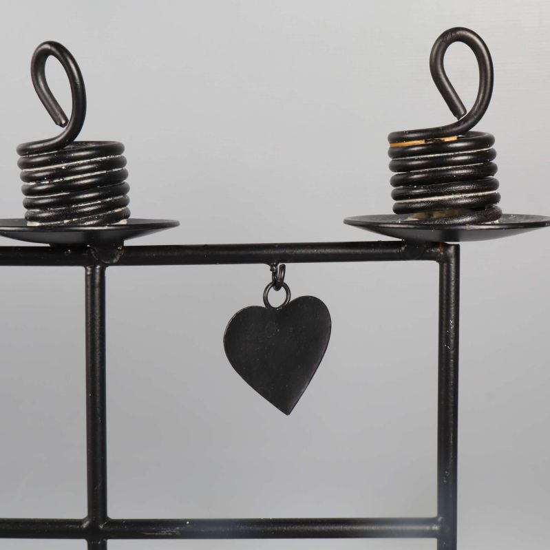 Närbild på två ljushållare och hängande hjärta