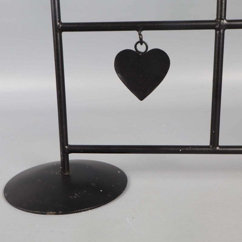 Närbild på bas och hängande hjärta på ljusstaken