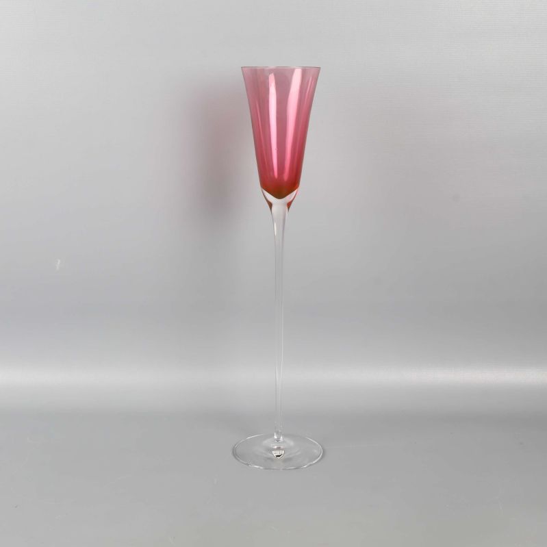 Högt glas med rosa kupa mot ljus bakgrund