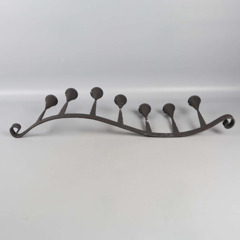 Ljusstake i metall sedd bakifrån med böjd form