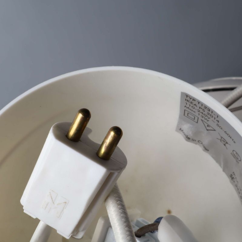 Vit tvåpolig elkontakt nära lampans plastkupa