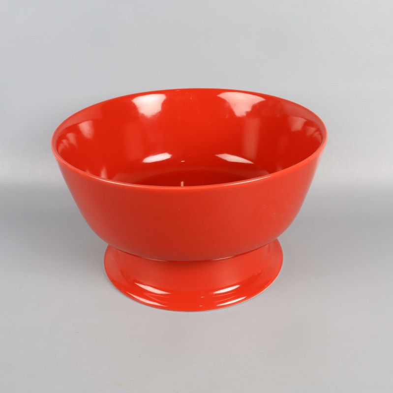 Röd skål med bred fot mot ljus bakgrund