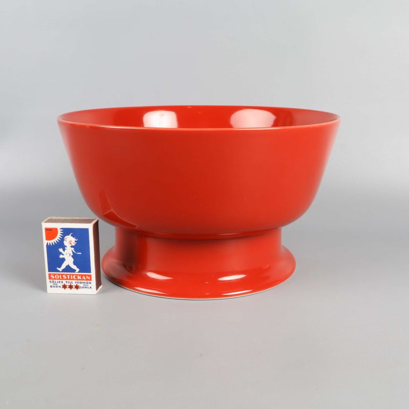 Röd skål bredvid tändsticksask för storleksjämförelse