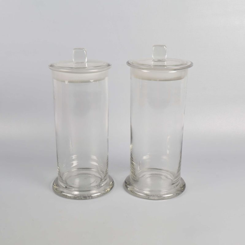 Två höga glasburkar med lock på vit bakgrund