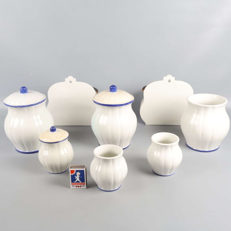 Baksidan av de åtta vita porslinsburkarna med blå kant