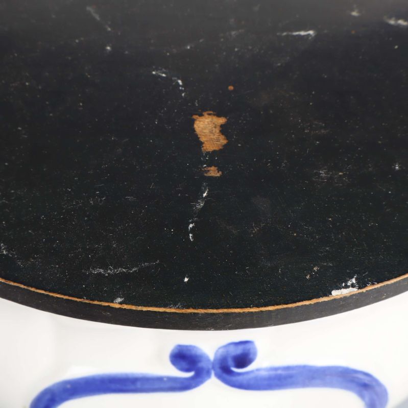 Närbild på svart trälock med slitage och märken