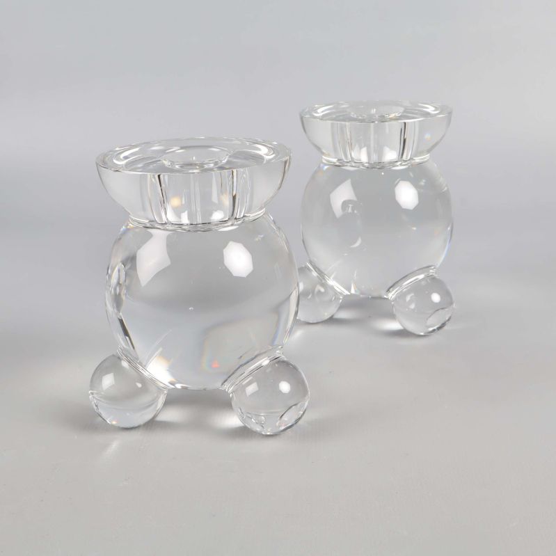 Perspektivvy av två rundade glasljusstakar på grå bakgrund