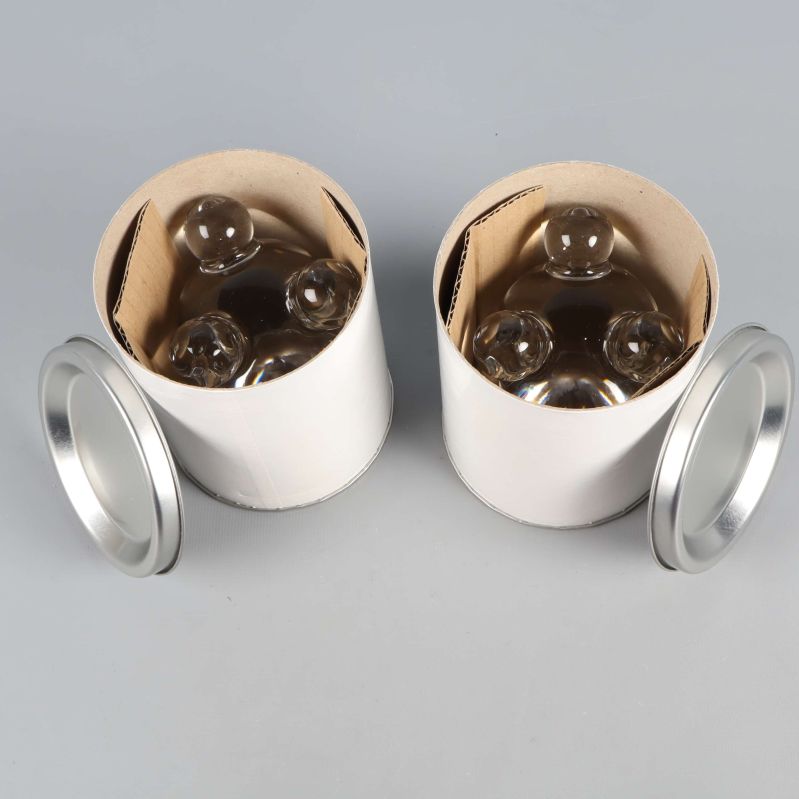 Ljusstakar placerade i öppna vita cylindriska förpackningar