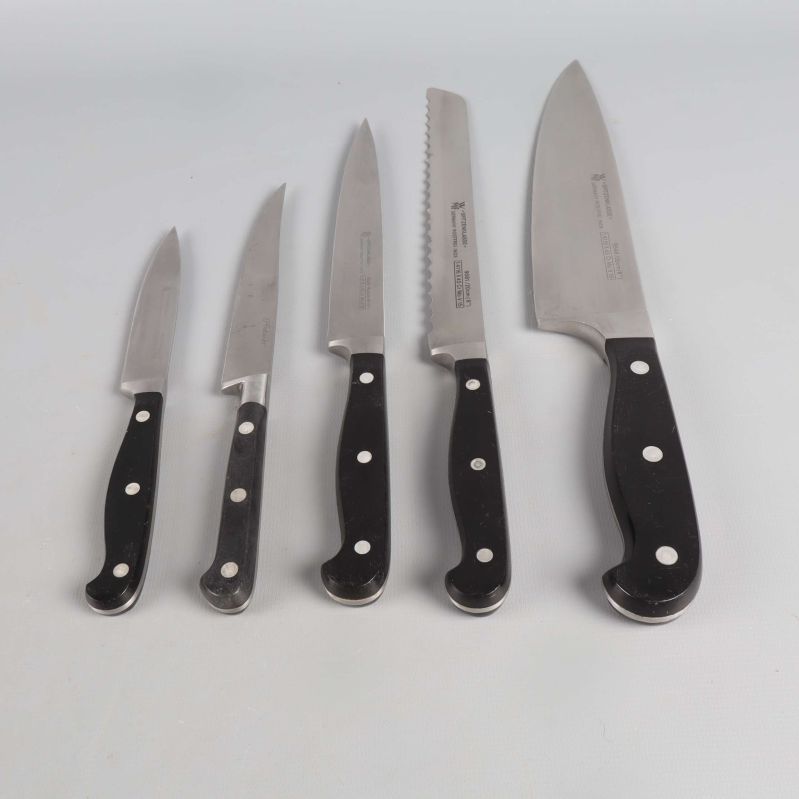 Fem köksknivar i varierande storlek med svarta handtag