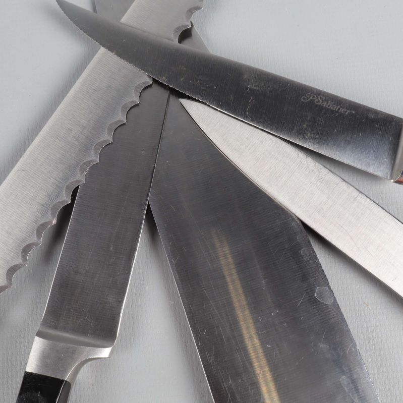 Närbild på knivblad med olika eggar och handtag