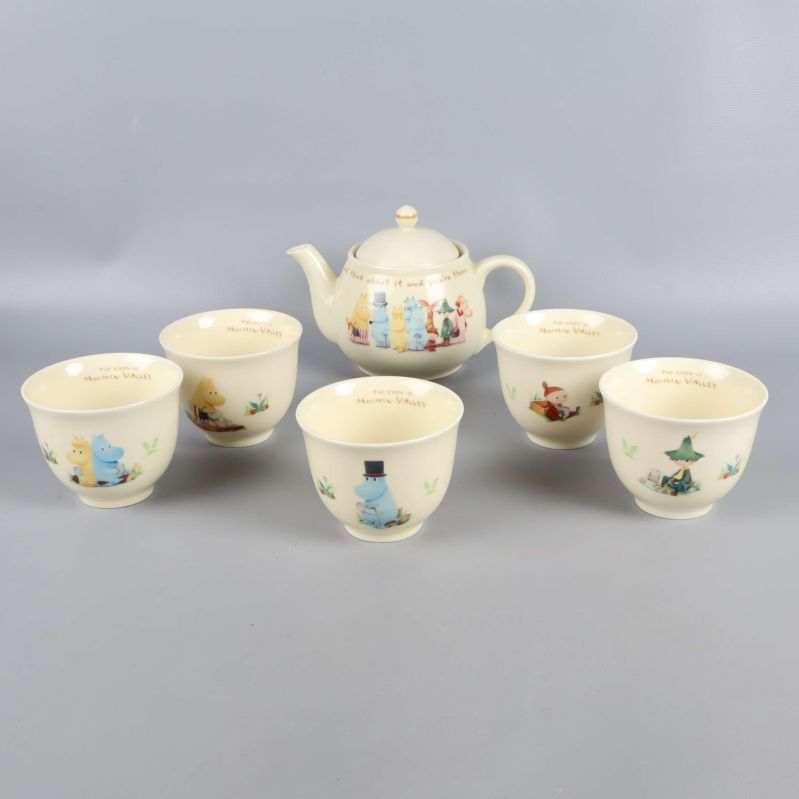Teservis med tekanna och fem koppar dekorerade med Mumintrollet-karaktärer