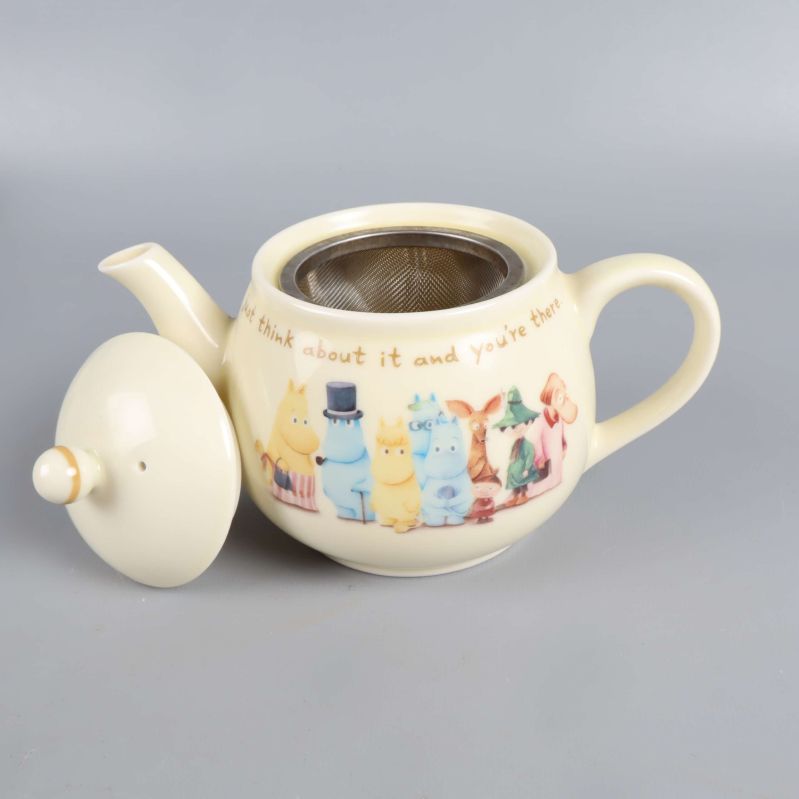 Närbild på tekanna med Mumintrollet-motiv och sil