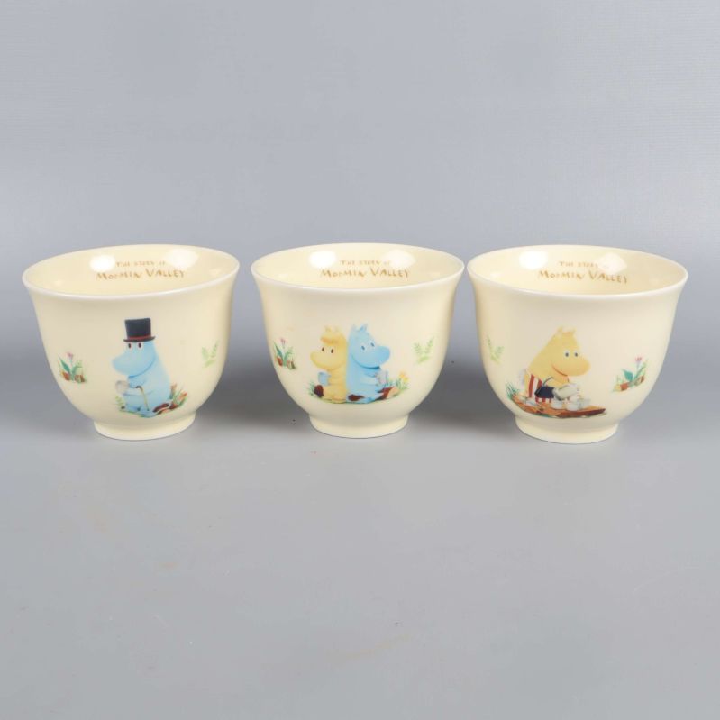 Tre koppar med olika Mumintrollet-motiv i rad