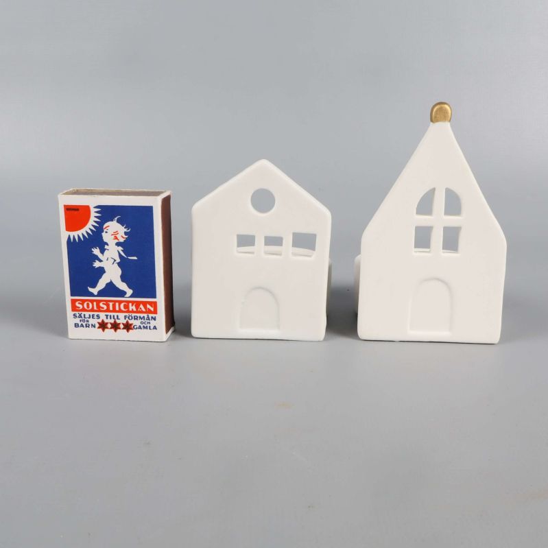 Ljushållare i form av hus jämte en tändsticksask för storleksjämförelse