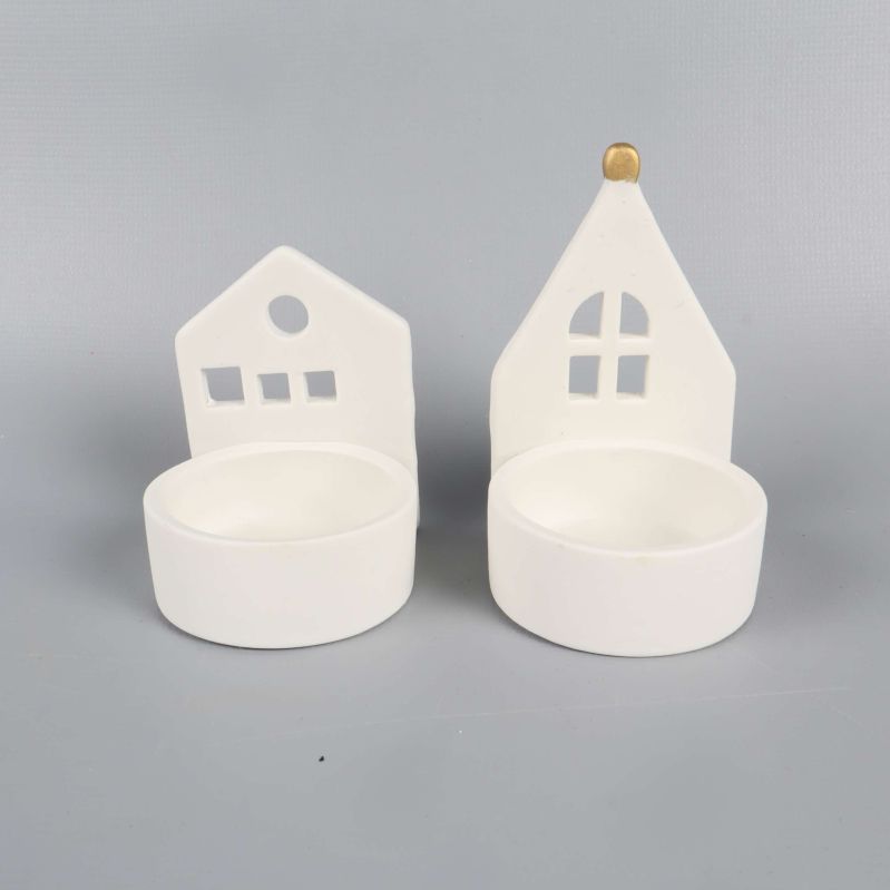 Husformade vita ljushållare sedda framifrån visar plats för värmeljus