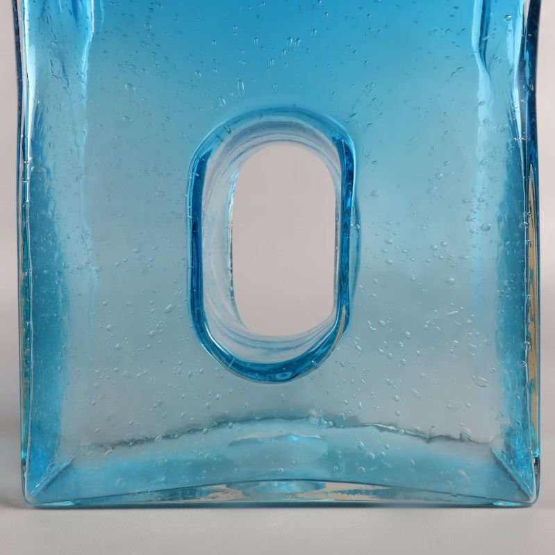 Närbild på håldesign i blå glasvas