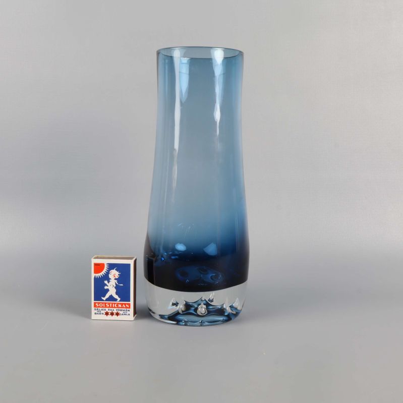 Blå glasvas jämte tändsticksask för storleksjämförelse