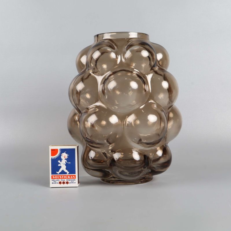 Vas i bubbligt glas bredvid tändsticksask för storleksreferens