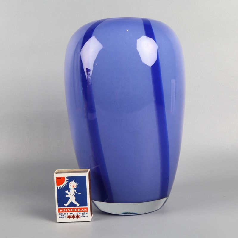 Stor blå glasvas med tändsticksask som storleksreferens