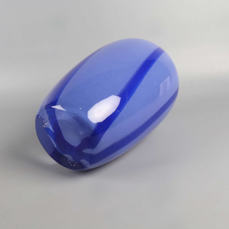 Blå vas liggandes på sidan, visar botten och ränder