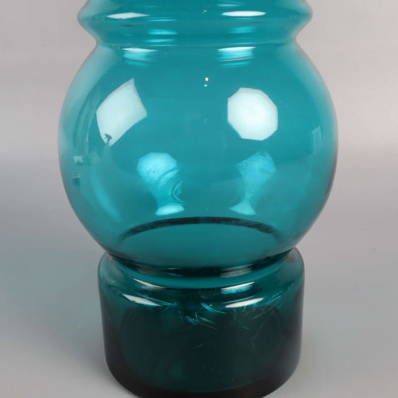 Närbild på vasens mitt och fot, grönt glas