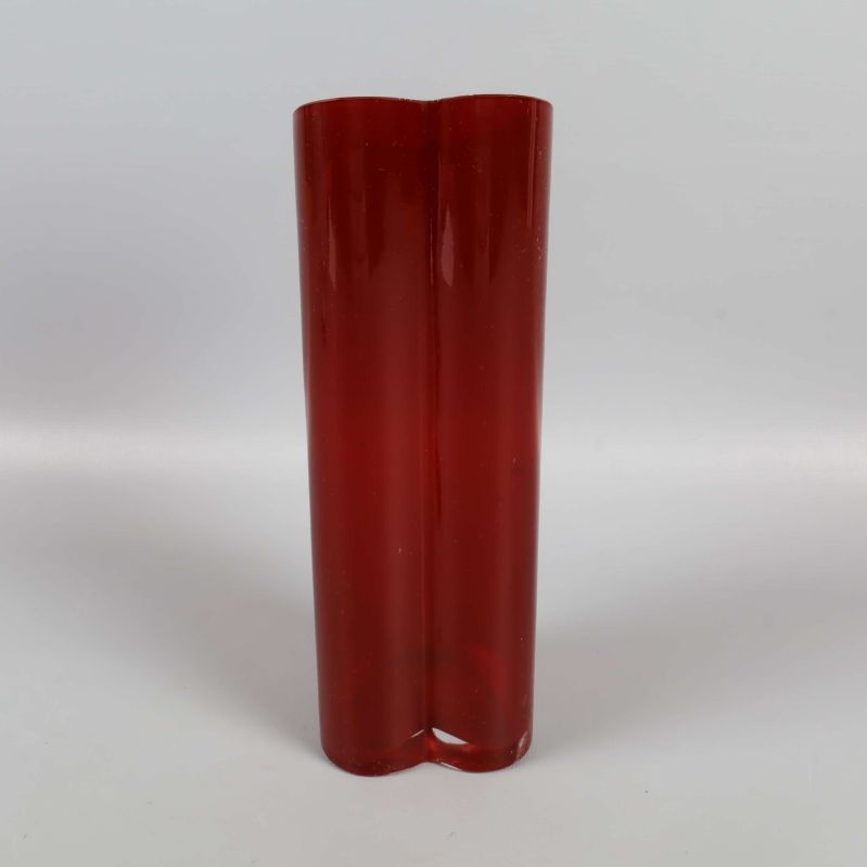 Röd hjärtformad vas sedd framifrån mot ljus bakgrund