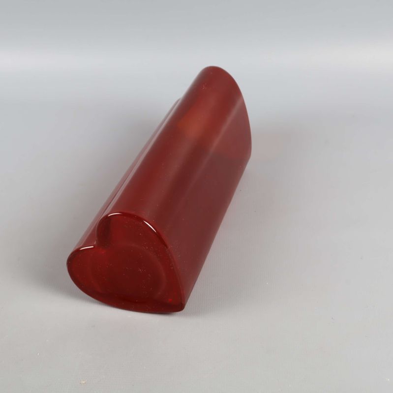 Röd hjärtformad vas liggande på sidan visar botten