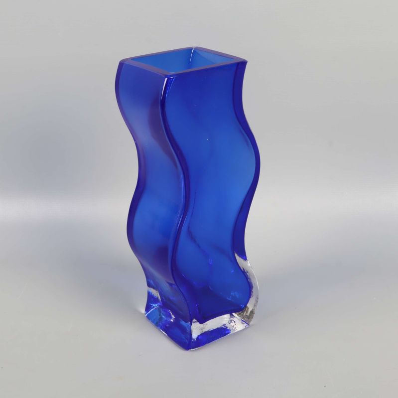 Blå vågig glasvas fotad snett framifrån