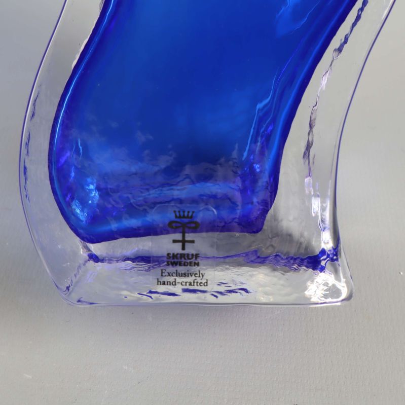 Närbild av Skruf-märke på blå glasvas