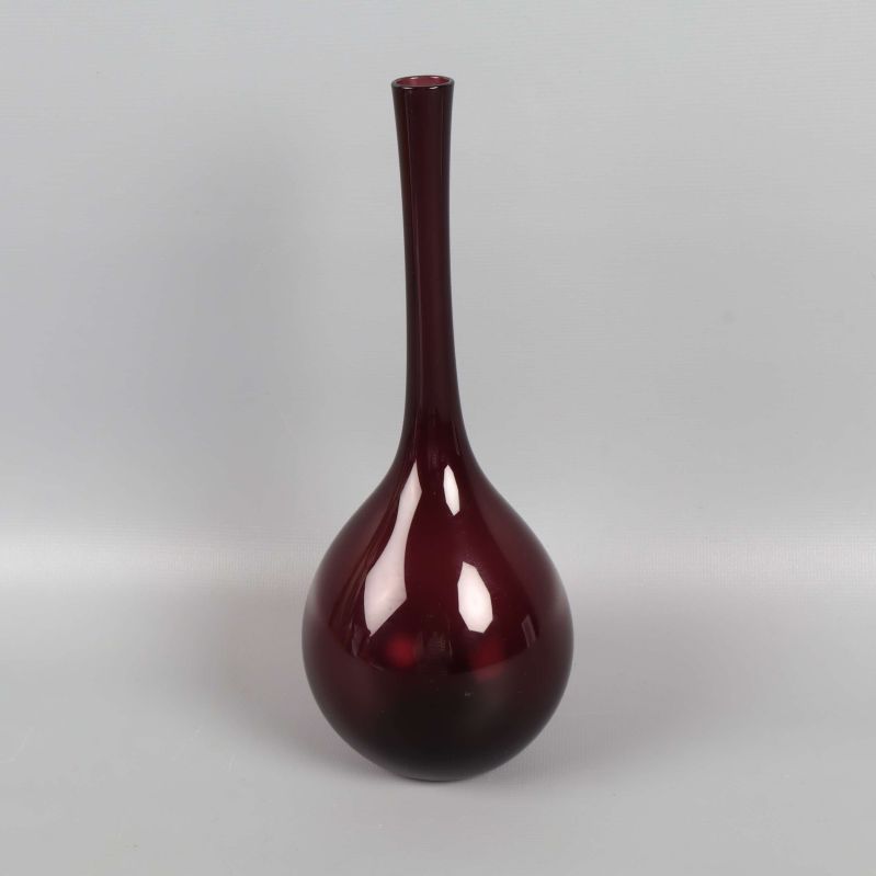 Smalhalsad vinröd vas mot grå bakgrund