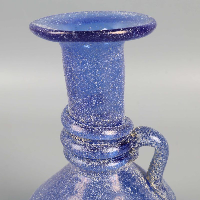 Närbild på hals och kant på blå glasvas