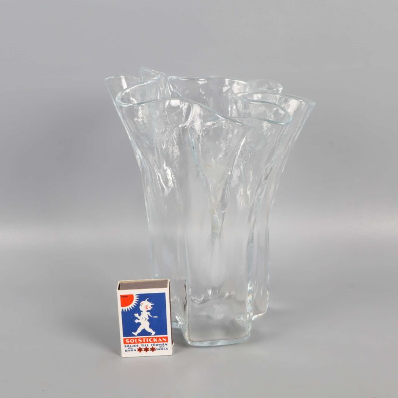 Vågig glasvas bredvid tändsticksask för storleksjämförelse