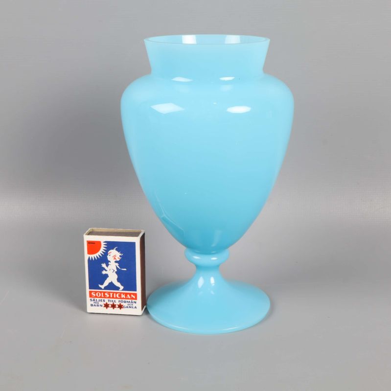 Blå vas jämte en tändsticksask för storleksjämförelse
