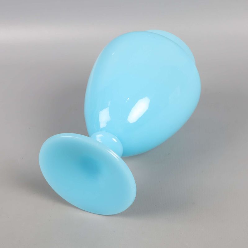 Blå vas liggande på sidan med synlig fot och öppning