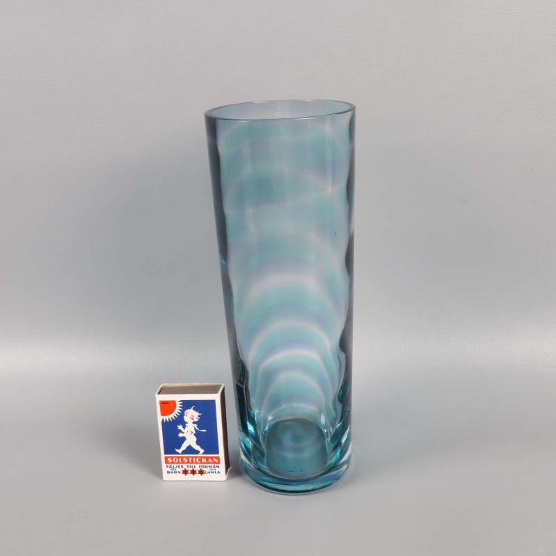 Blå glasvas bredvid tändsticksask för storleksjämförelse