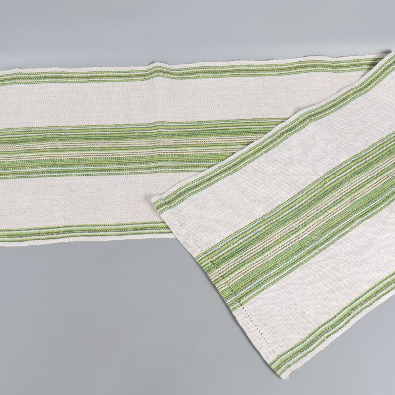 Vit löpare med gröna ränder utvikt på grått underlag