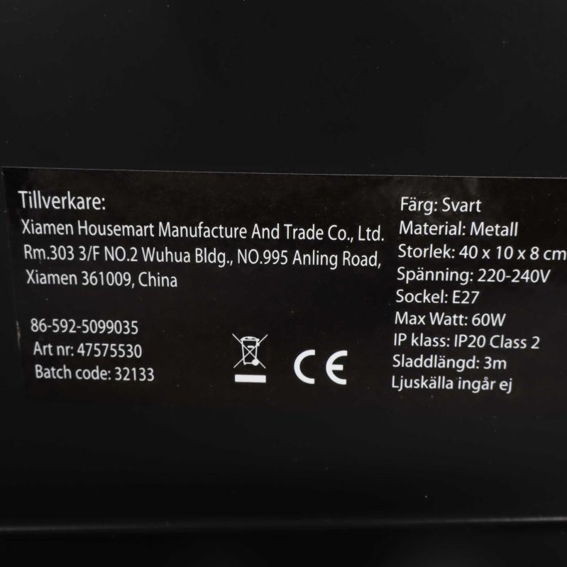 Närbild av produktetikett med material och färg på lampan