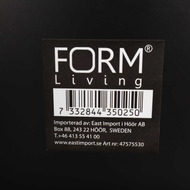 Närbild av FORM Living logotyp på lampans etikett