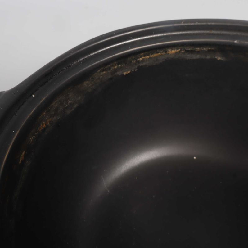 Närbild av grytas insida med användningsspår längs kanten