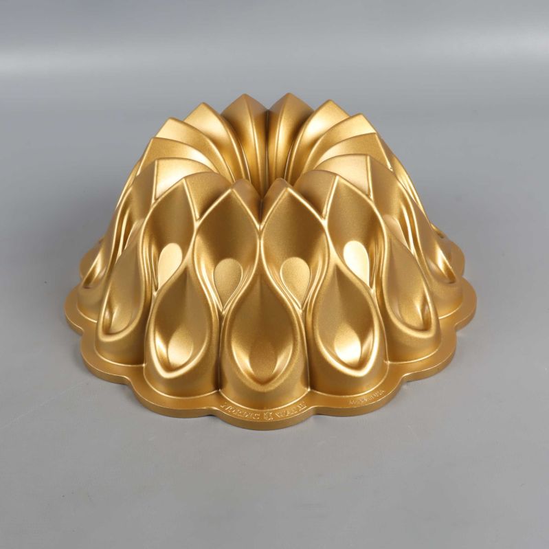 Dekorativ bakform i guld med reliefmönster sedd framifrån