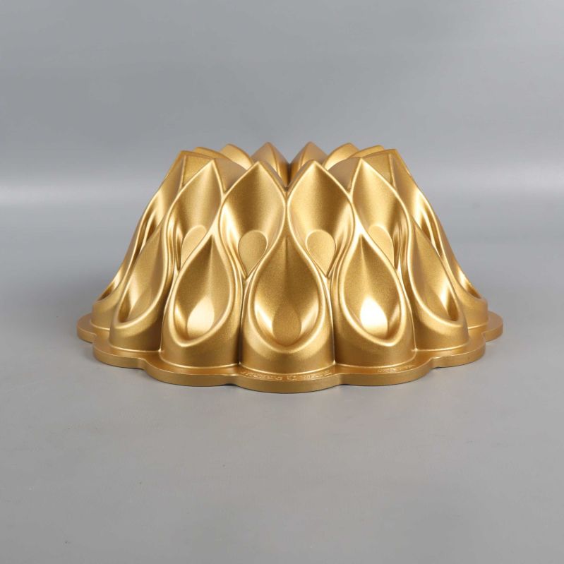 Guldfärgad bakform med unik form sedd från sidan