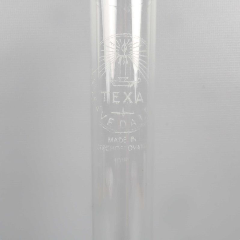 Närbild av glasrör med Texa-märkning och text