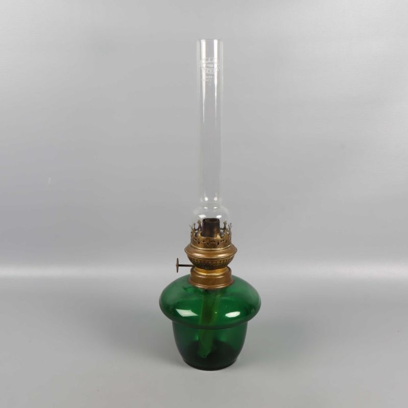 Fotogenlampa med grön glaskupa och mässingsdetaljer, centrerad mot grå bakgrund