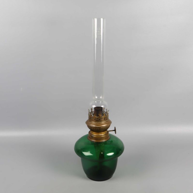 Fotogenlampa med lång glascylinder och mässingsdetaljer fotograferad snett framifrån