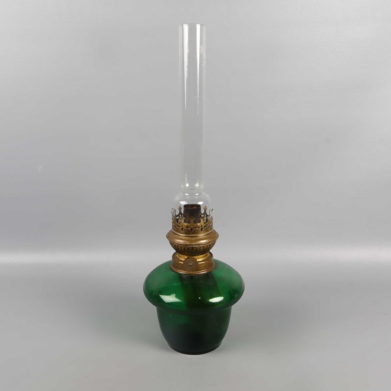 Fotogenlampa i grön glas och mässing fotograferad framifrån med något vinklad kupa